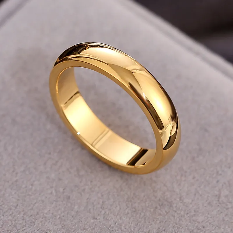 Polished gold ring with a sleek, smooth finish placed on a neutral surface.