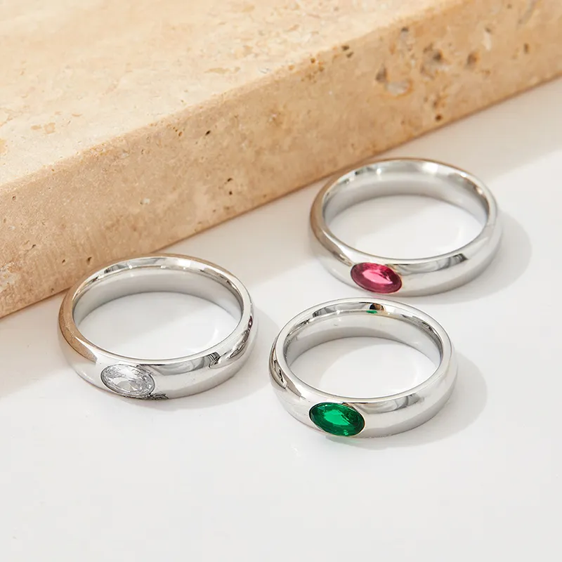 Trio of silver rings with oval cubic zirconia stones in clear, red, and green.