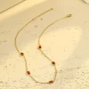 Gold necklace with five rectangular red cubic zirconia stones set in gold, showcasing a refined and elegant design.