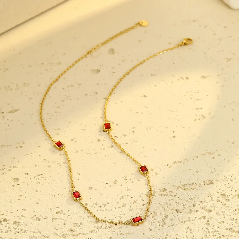 Gold necklace with five rectangular red cubic zirconia stones set in gold, showcasing a refined and elegant design.