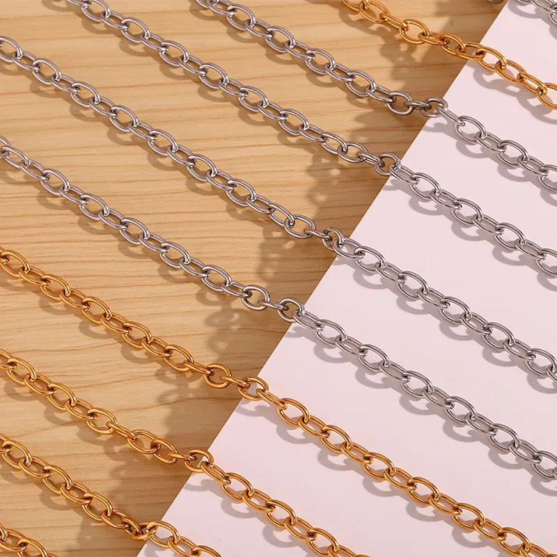 A collection of gold and silver link chain necklaces displayed on a wooden and white background, highlighting their timeless and elegant design.