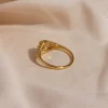 Gold ring with detailed filigree design and pearl accent, viewed from the back.