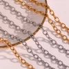 Close-up of chunky gold and silver link chain necklaces displayed on a decorative plate, showcasing their bold and stylish design.