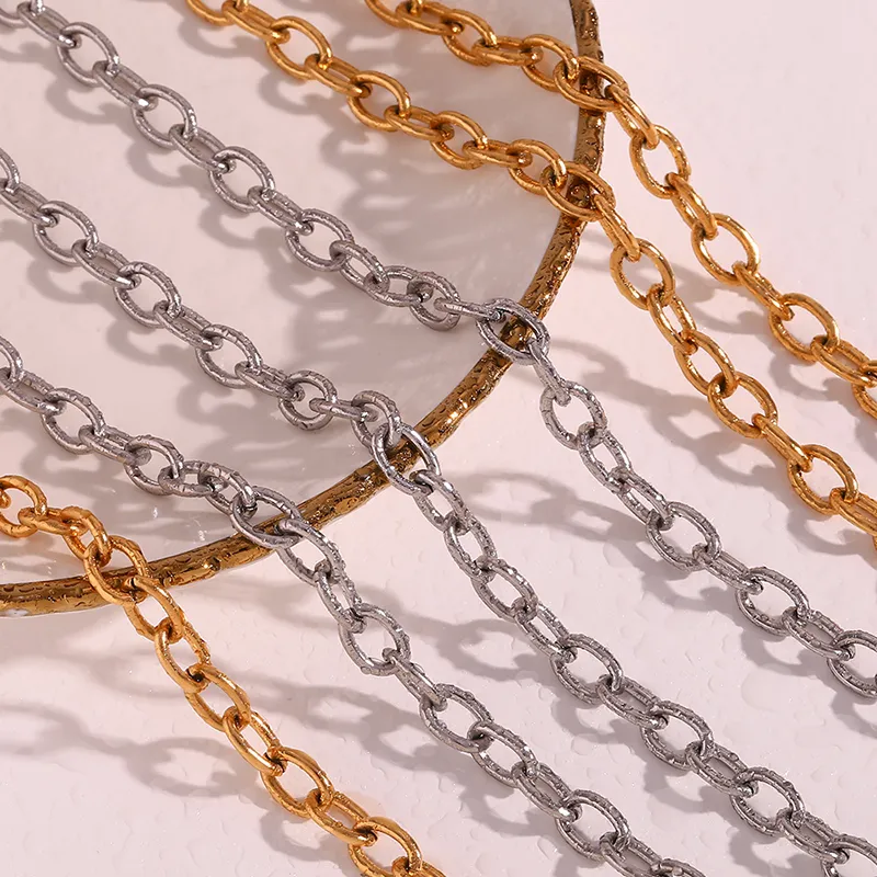 Close-up of chunky gold and silver link chain necklaces displayed on a decorative plate, showcasing their bold and stylish design.