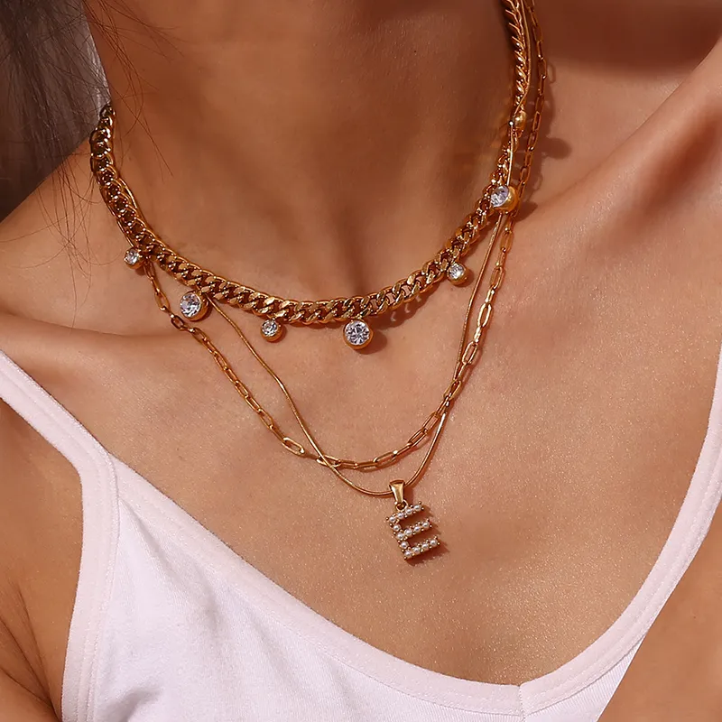18K gold "E" initial necklace with pearl details on layered gold chains, featuring sparkling crystals, waterproof and durable.