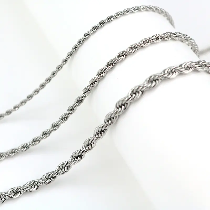 A display of stainless steel rope chain necklaces in various thicknesses, arranged on a white stand to highlight their intricate twisted-link design.