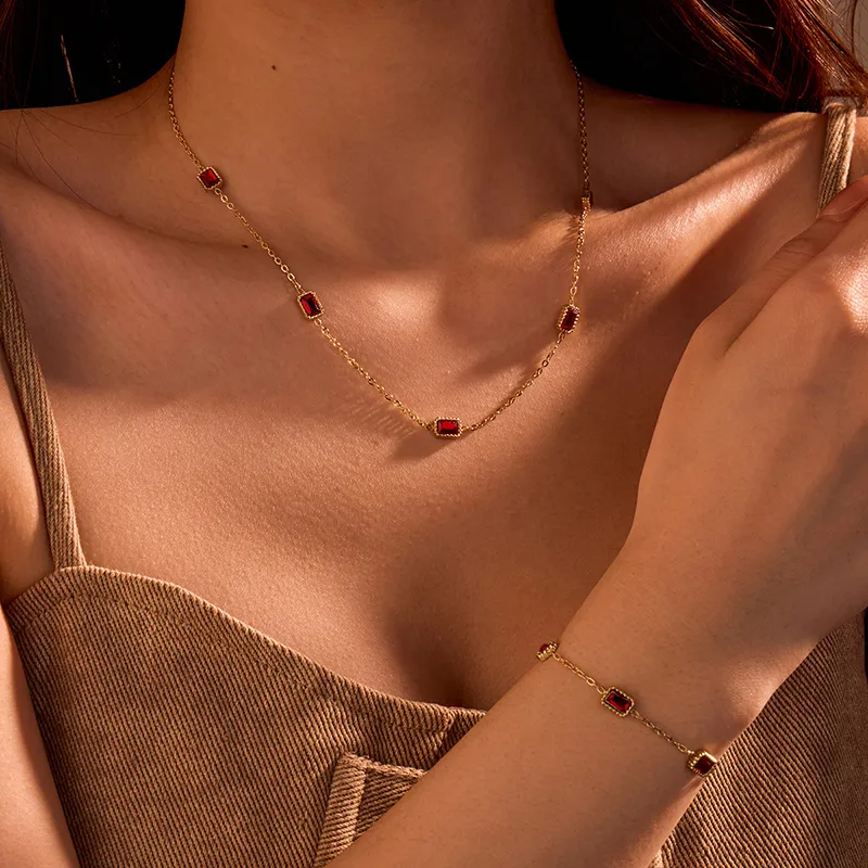 Gold necklace and bracelet set with rectangular red cubic zirconia stones, set in a sleek and elegant design.