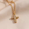 Gold cross necklace adorned with cubic zirconia crystals, suspended from a fine gold chain.