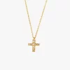Gold cross necklace with cubic zirconia crystals, hanging from a fine gold chain.