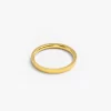 A sleek gold band ring on a neutral background, highlighting its minimalist elegance.