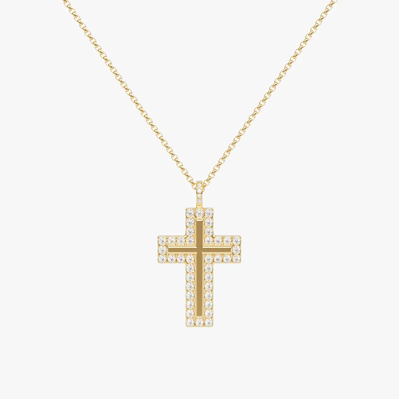 Gold cross pendant necklace set with cubic zirconia crystals, hanging from a fine chain against a white background.