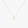 Gold necklace with a pear-shaped pearl pendant, highlighted by small sparkling stones around the pearl, resting on a smooth gold chain.