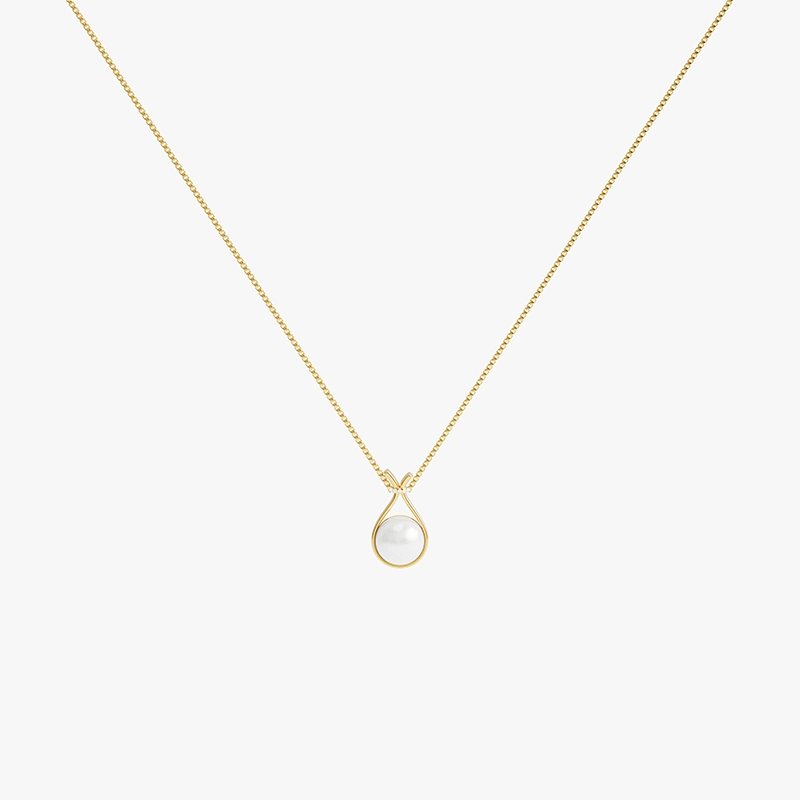 Gold necklace with a pear-shaped pearl pendant, highlighted by small sparkling stones around the pearl, resting on a smooth gold chain.