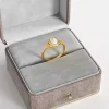 A vintage-style 18K gold-plated filigree ring with a white pearl, elegantly displayed in a gray velvet jewelry box, showcasing its intricate detailing and timeless appeal.