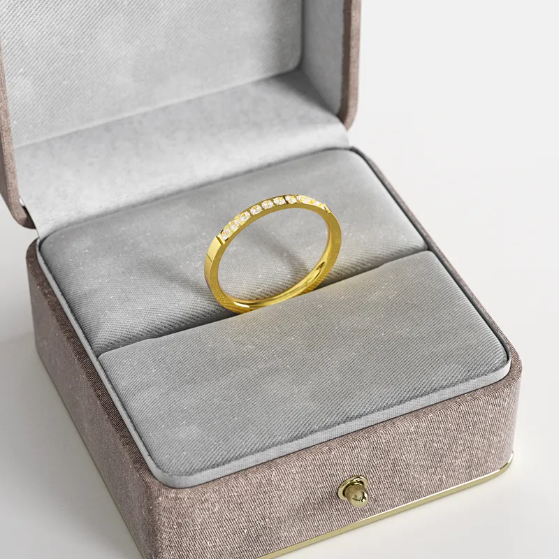 A thin 18K gold ring with 10 cubic zirconia stones, displayed in a gray velvet jewelry box, highlighting its delicate and elegant design.