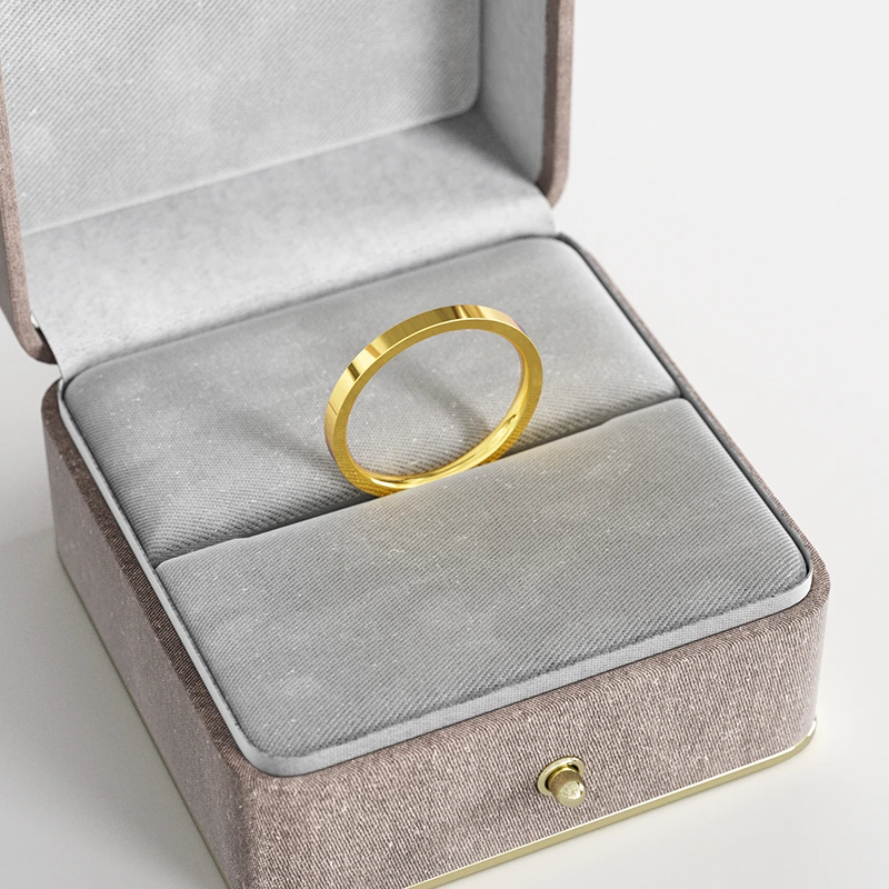 A sleek 18K gold flat-edge band ring, displayed in a gray velvet jewelry box, highlighting its minimalist and modern design.
