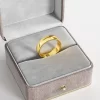 A wide 18K gold-plated band ring with a smooth polished finish, displayed in a gray velvet jewelry box, highlighting its classic and elegant design.