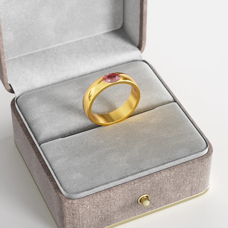 A 18K gold ring with a red cubic zirconia stone, elegantly displayed in a gray velvet jewelry box, emphasizing its modern and bold design.
