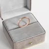 A rose gold flat-edge band ring, displayed in a gray velvet jewelry box, highlighting its minimalist and modern design.