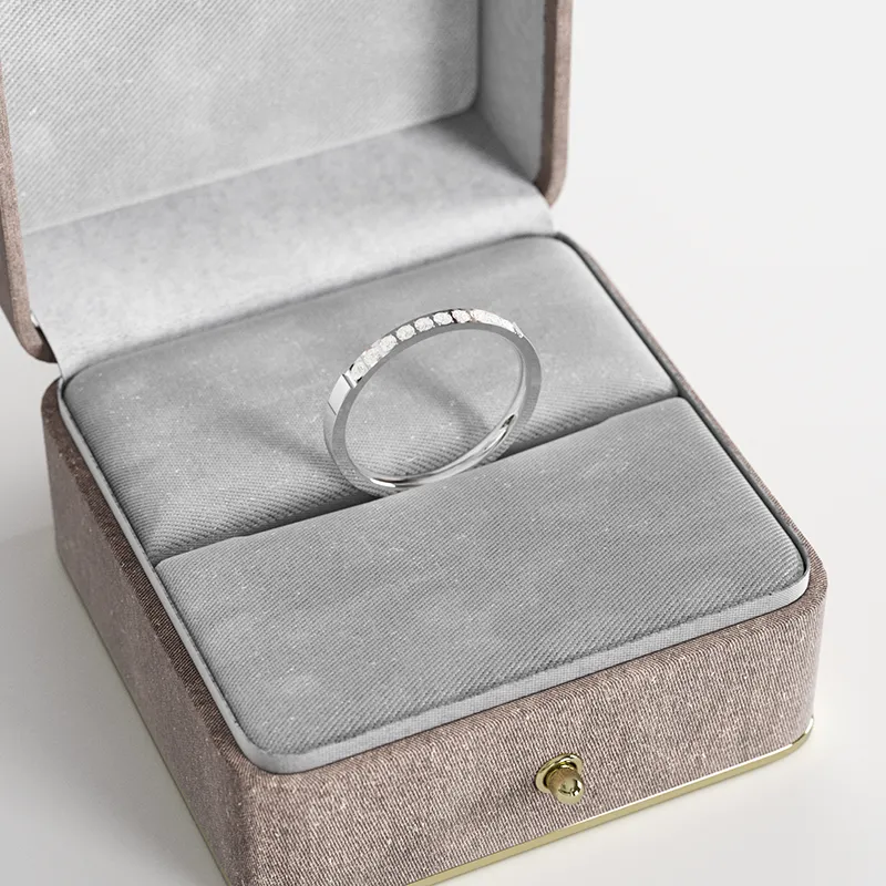 A thin stainless steel ring with 10 cubic zirconia stones, displayed in a gray velvet jewelry box, showcasing its minimalist and elegant design.