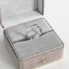 A stainless steel wide band ring with a polished finish, elegantly displayed in a gray velvet jewelry box, showcasing its sleek and modern design.