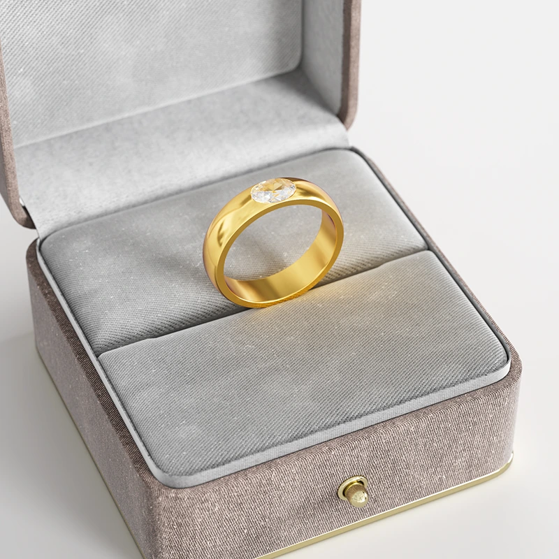 A 18K gold ring with a clear cubic zirconia stone, elegantly displayed in a gray velvet jewelry box, emphasizing its modern and bold design.