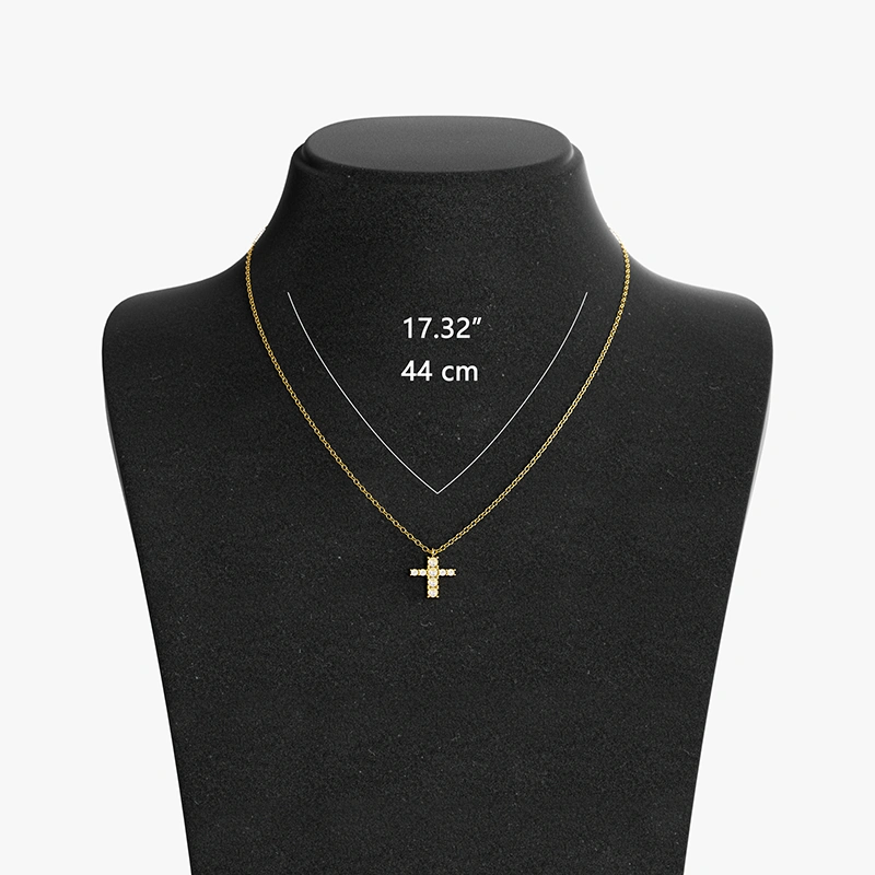 An 18K gold cross pendant necklace with cubic zirconia, displayed on a black mannequin with chain length measurements for reference.