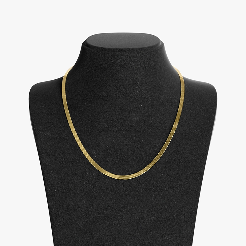18K gold herringbone chain necklace with a smooth, flat design, displayed on a black velvet bust for a classic and luxurious look.