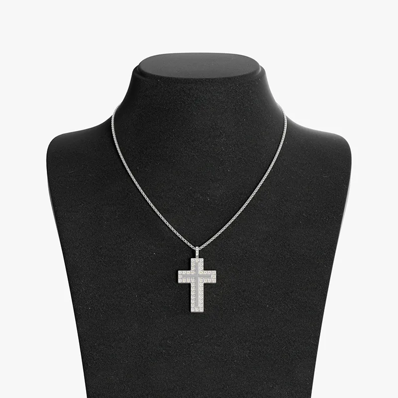 Stainless steel cross pendant necklace with shimmering stones, displayed on a black velvet bust, highlighting its sleek and modern design.
